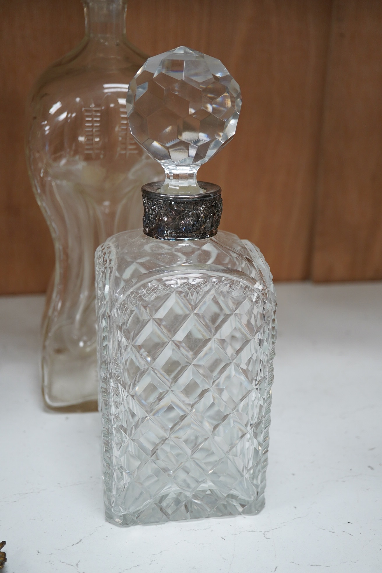 Six 19th century and later cut glass decanters and stoppers, one with white metal acorn design collar, largest 37cm high. Condition - fair, some chipping / impact damage